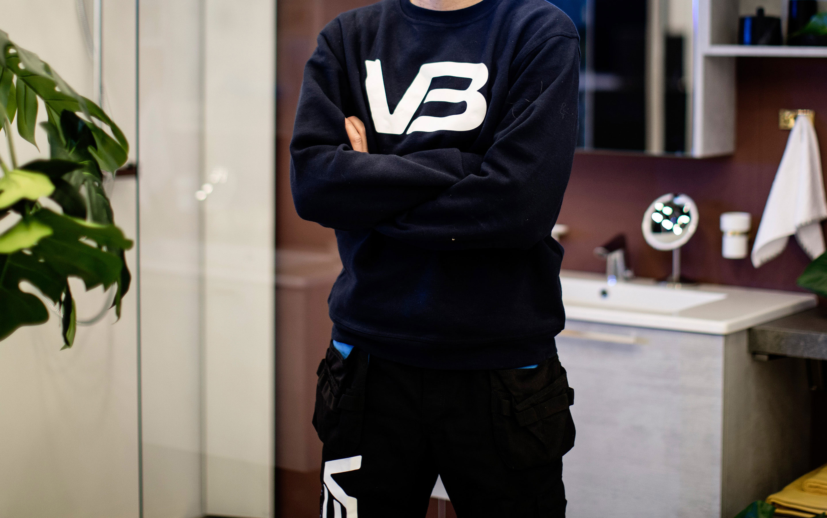 VB-rørlegger med armene i korts med bedriftslogo på arbeidsgenseren sin